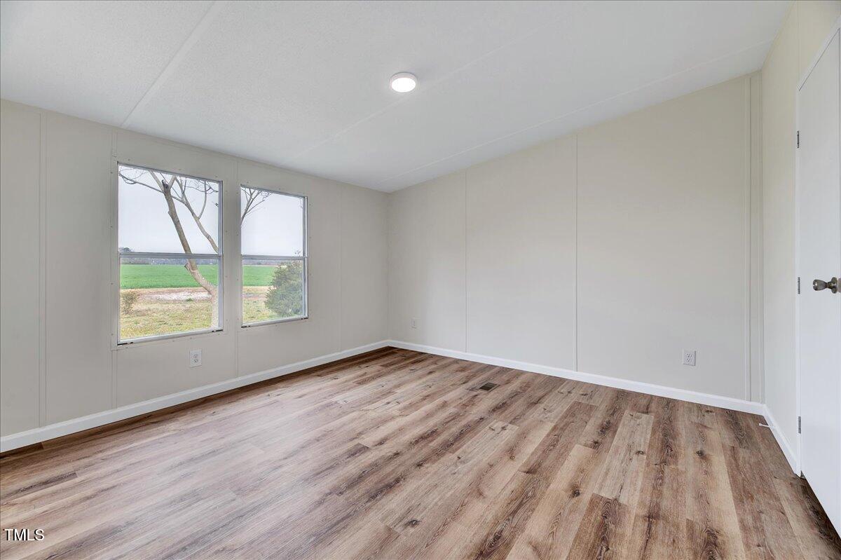 10942 Simms Road Bailey, NC 27807 - Photo 27 of 44 an empty room with wooden floor and windows