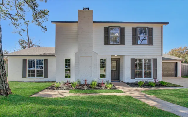 a front view of a house with a garden and yard