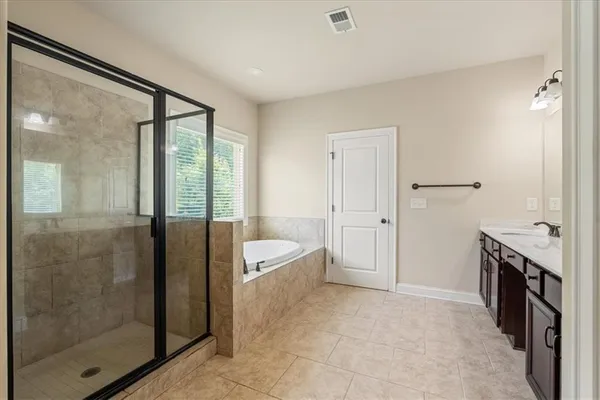 a spacious bathroom with a bathtub and a shower