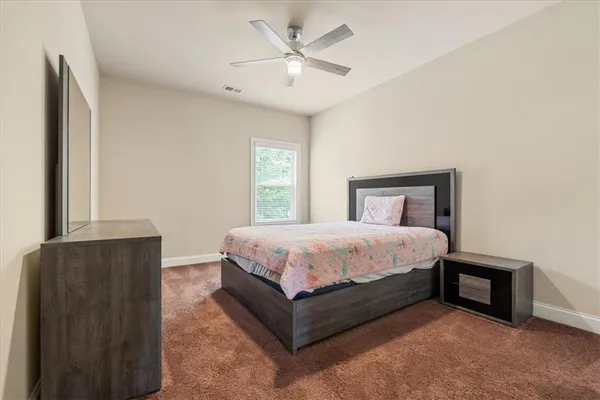 a spacious bedroom with a bed and a chandelier