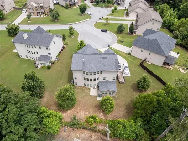 an aerial view of a house with garden space and a swimming pool