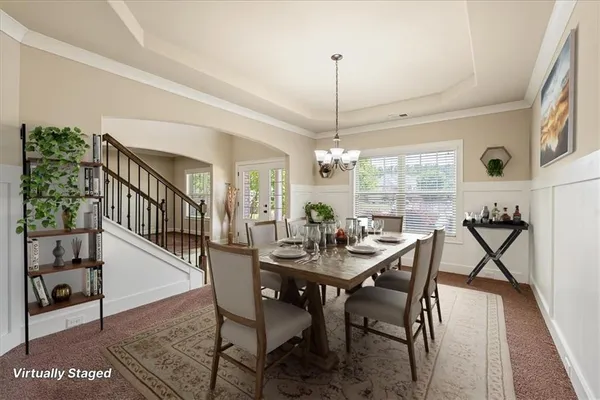a view of a dining room and livingroom with furniture wooden floor a chandelier