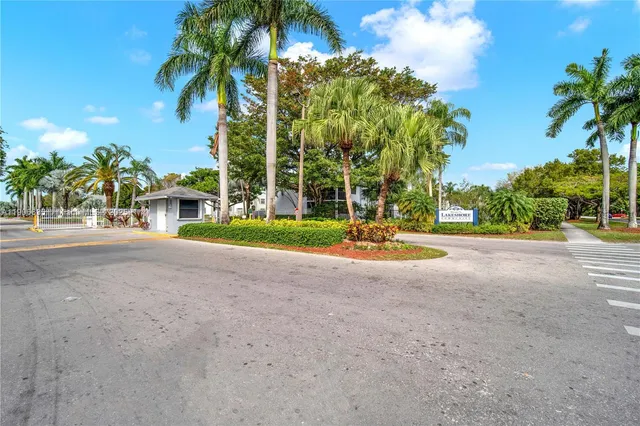 a view of a house with a yard and palm trees