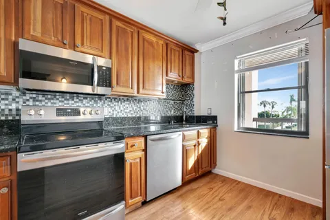 a kitchen with stainless steel appliances granite countertop a stove microwave and cabinets