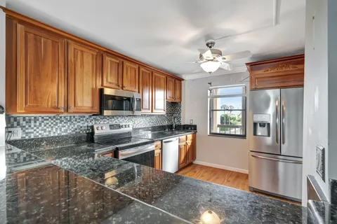 a kitchen with stainless steel appliances granite countertop a refrigerator a stove top oven a sink and dishwasher