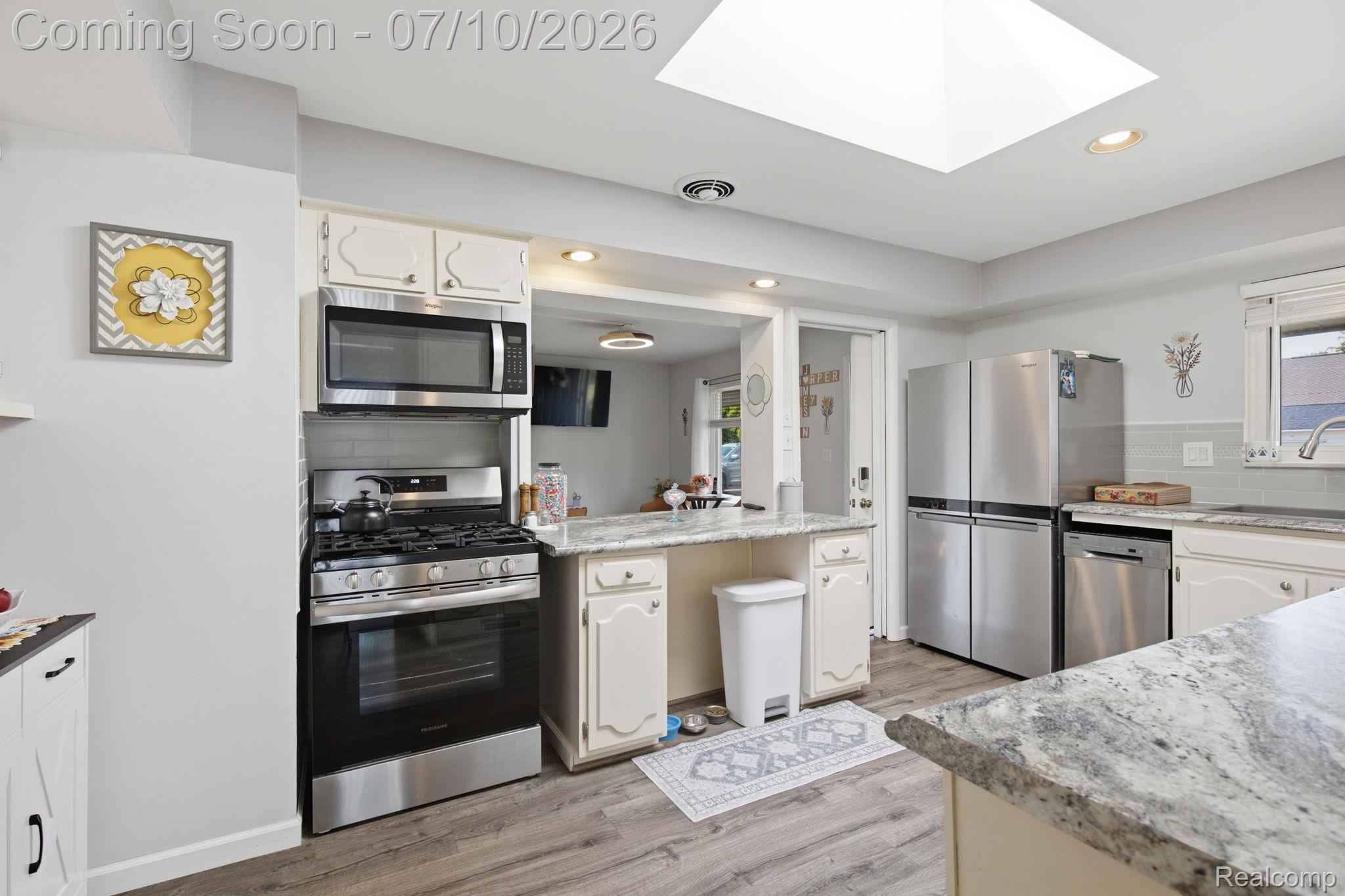 1501 River Road, Unit 301 St. Clair, MI 48079 - Photo 7 of 32 Kitchen featuring stainless steel appliances, light-toned cabinetry, granite countertops, and wood-finish flooring