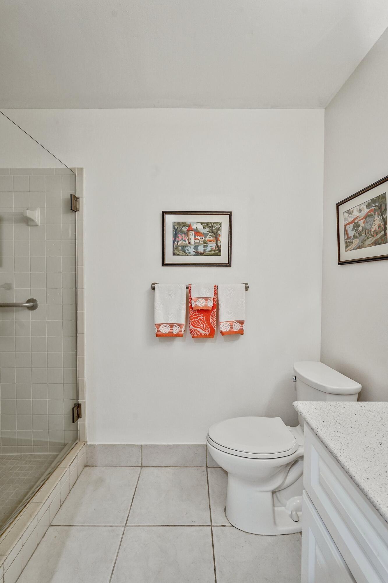 13960 Nesting Way, Unit C Delray Beach, FL 33484 - Photo 15 of 30 a white toilet sitting next to a bathroom sink