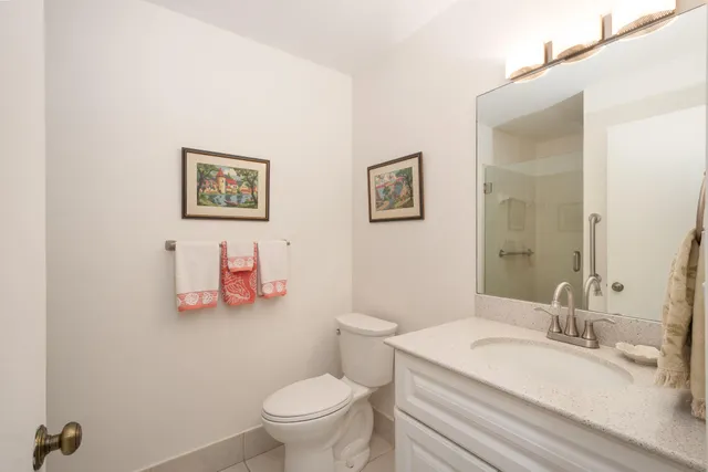 a bathroom with a granite countertop sink mirror vanity and toilet