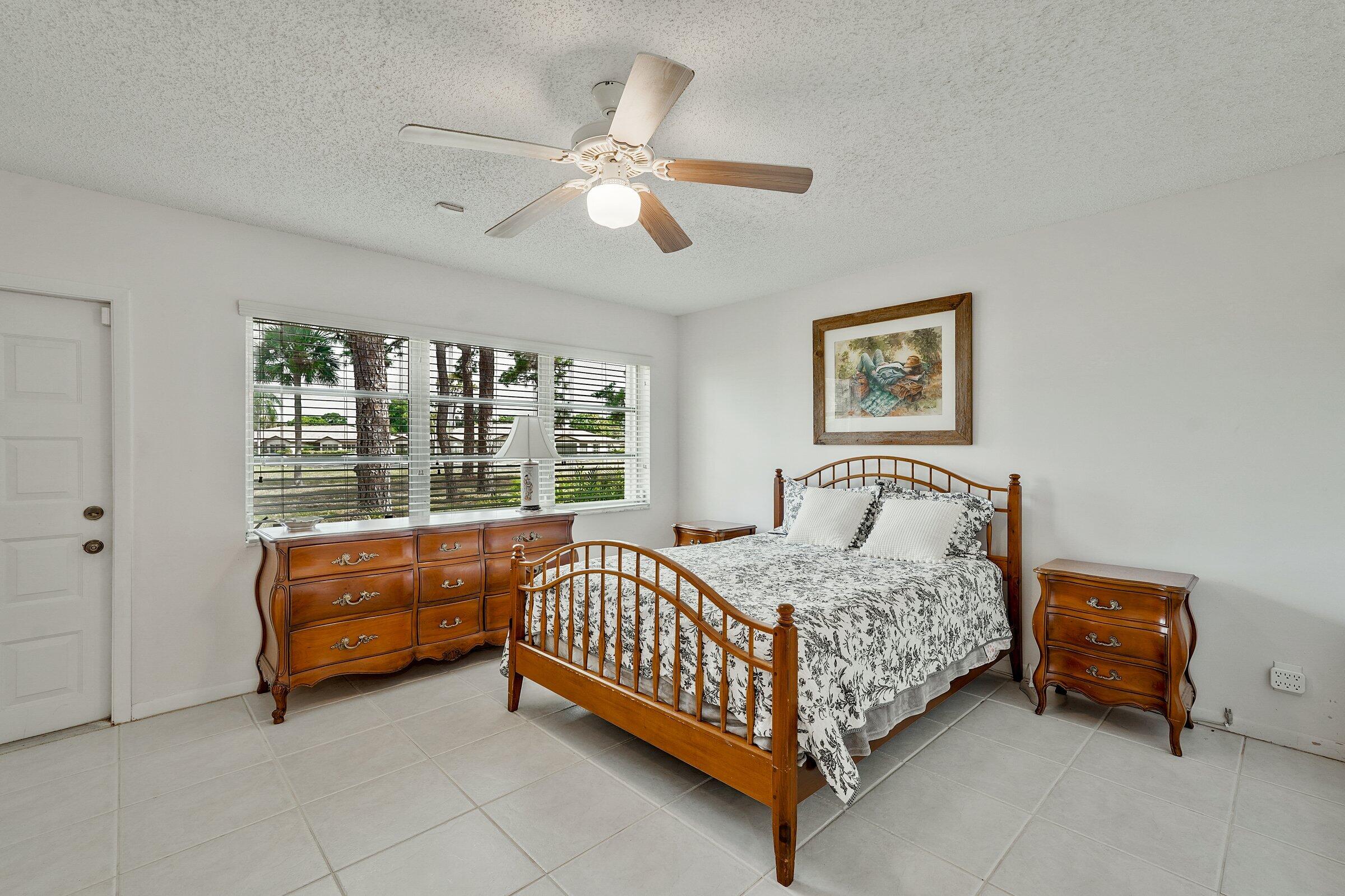 13960 Nesting Way, Unit C Delray Beach, FL 33484 - Photo 19 of 30 a bedroom with a bed and a chandelier