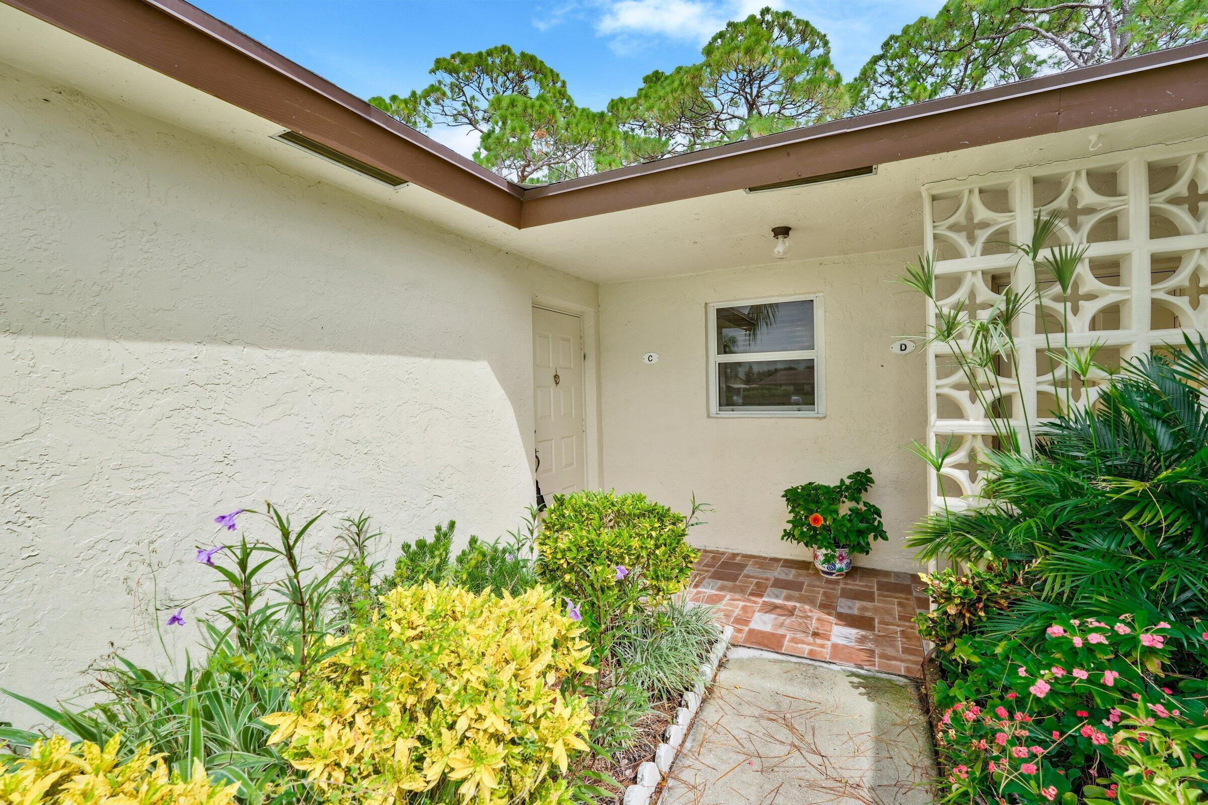 13960 Nesting Way, Unit C Delray Beach, FL 33484 - Photo 2 of 30 a potted plant sitting in front of a door