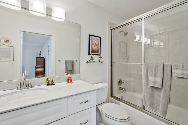 a bathroom with a sink vanity granite toilet and shower