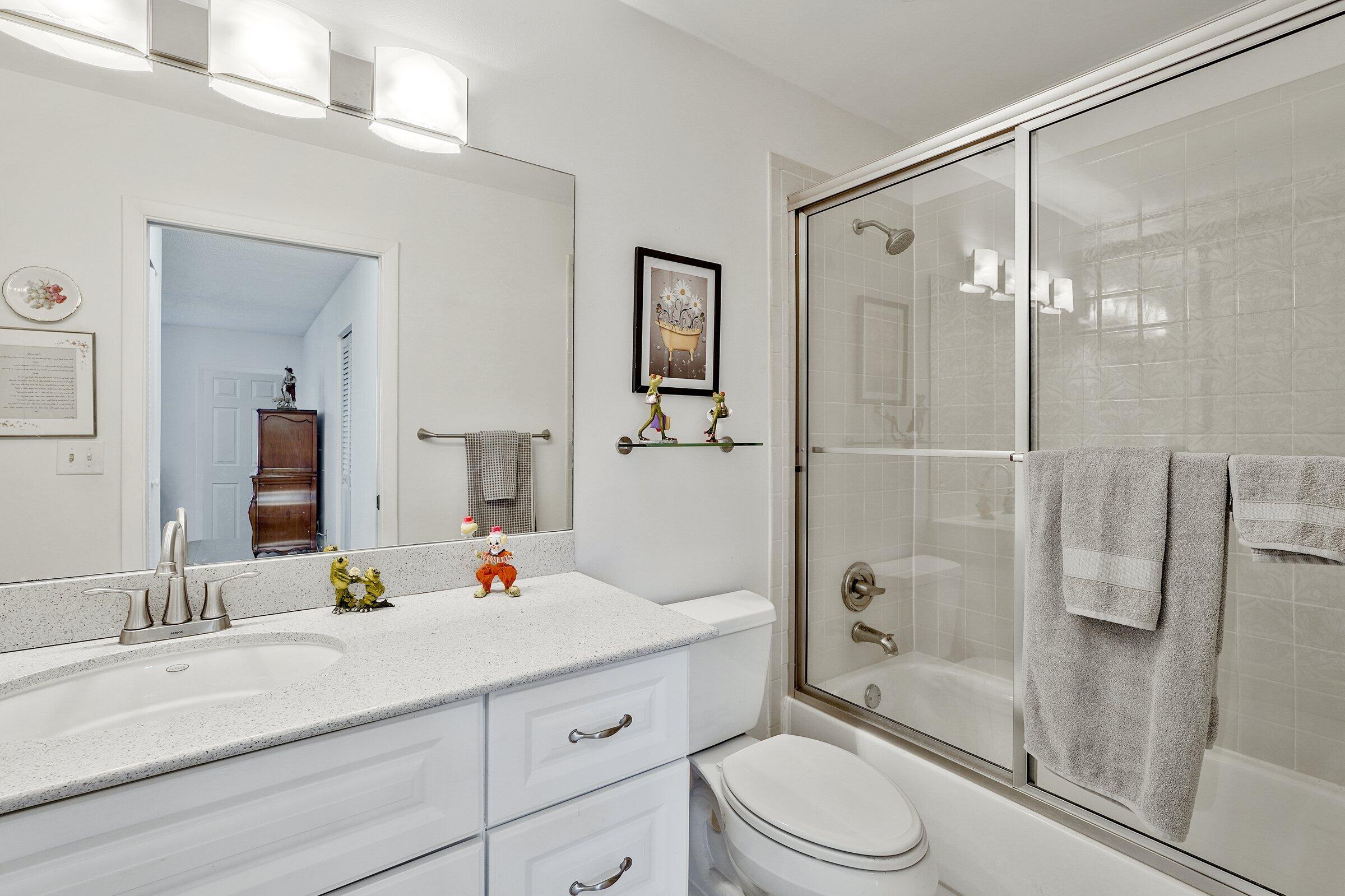 13960 Nesting Way, Unit C Delray Beach, FL 33484 - Photo 21 of 30 a bathroom with a sink vanity granite toilet and shower