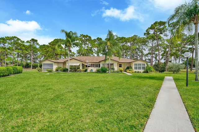 a view of a house with garden and a trees