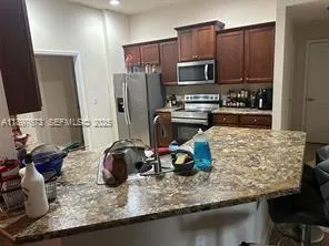 a kitchen with granite countertop a sink appliances and cabinets