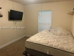 a room with a flat screen tv and a wooden floor