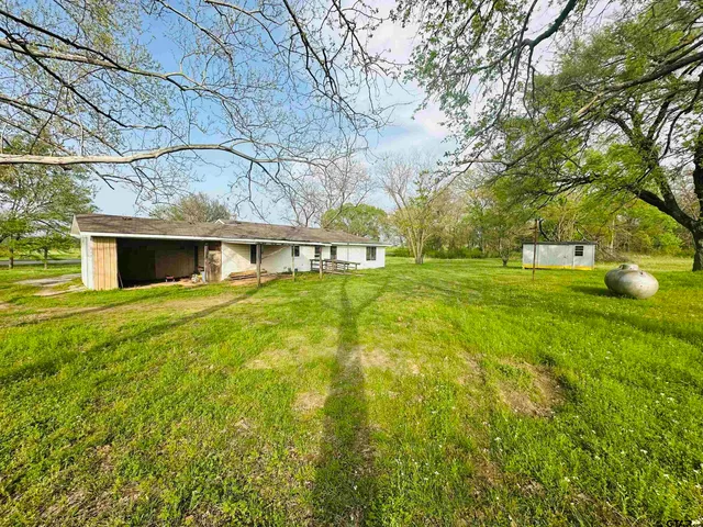 a backyard of a house with lots of green space and fountain