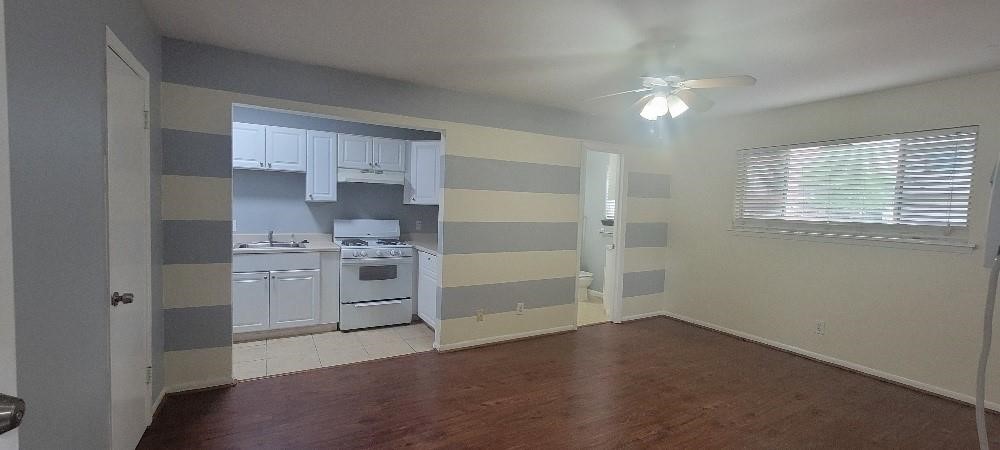 1806 West Main Street, Unit 5 Houston, TX 77098 - Photo 3 of 8 a room with a white cabinets and chandelier