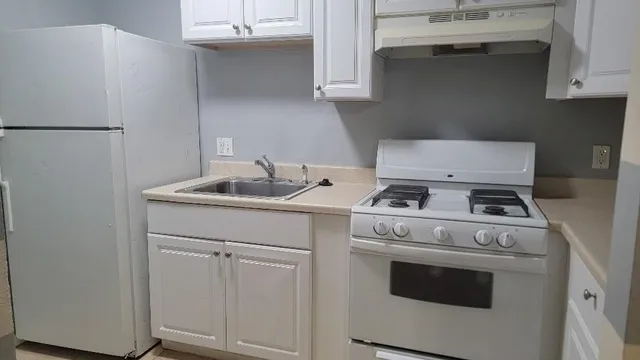 a white stove top oven sitting inside of a kitchen