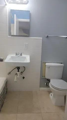 a bathroom with a sink a toilet and mirror