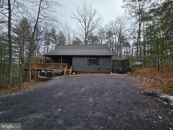 a backyard of a house with barbeque oven and trees
