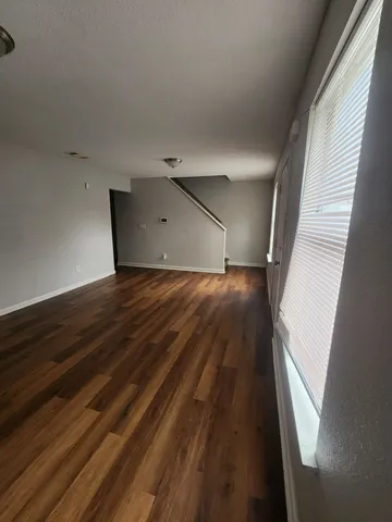 a view of a big room with wooden floor and windows