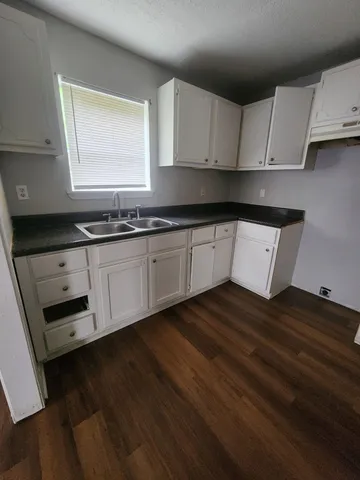 a kitchen with granite countertop a stove a sink and a microwave