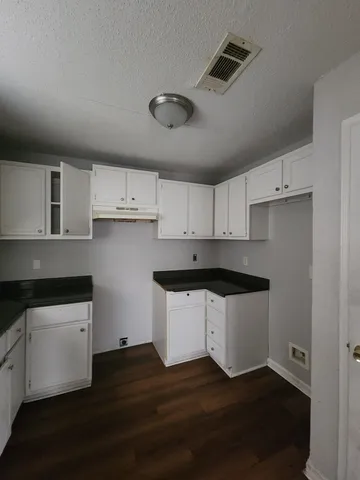 a kitchen with granite countertop a sink cabinets and stainless steel appliances