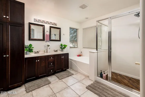 a bathroom with a double vanity sink mirror and shower