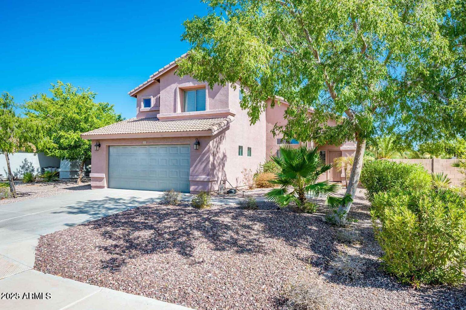 13604 West Rovey Avenue Litchfield Park, AZ 85340 - Photo 3 of 33 a front view of a house with a yard and garage