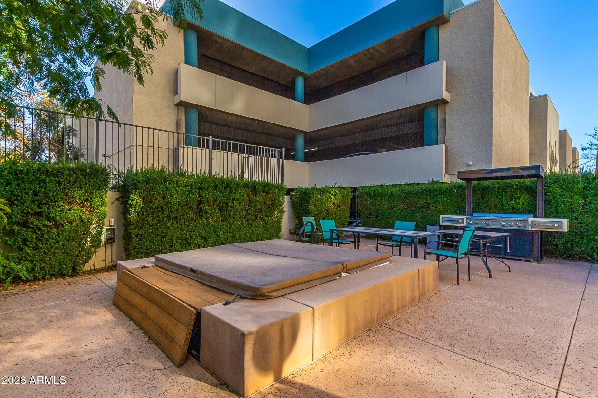 207 West Clarendon Avenue, Unit B2 Phoenix, AZ 85013 - Photo 23 of 30 a view of a patio with table and chairs potted plants and palm tree
