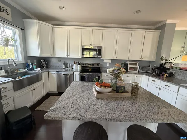 a kitchen with stainless steel appliances granite countertop a sink a stove top oven a counter space and cabinets
