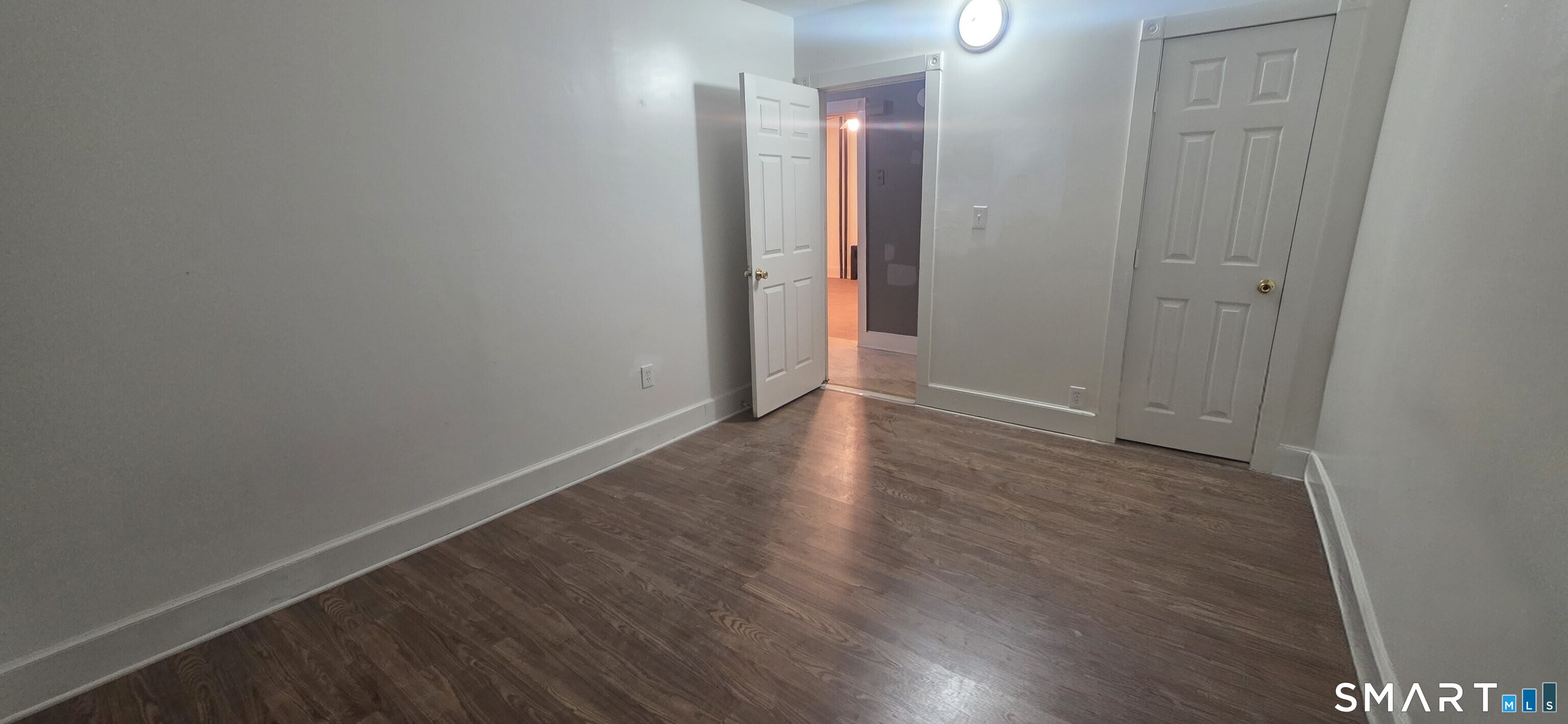 137 Birch Street, Unit 139 Manchester, CT 06040 - Photo 9 of 14 a view of an empty room with wooden floor and a window