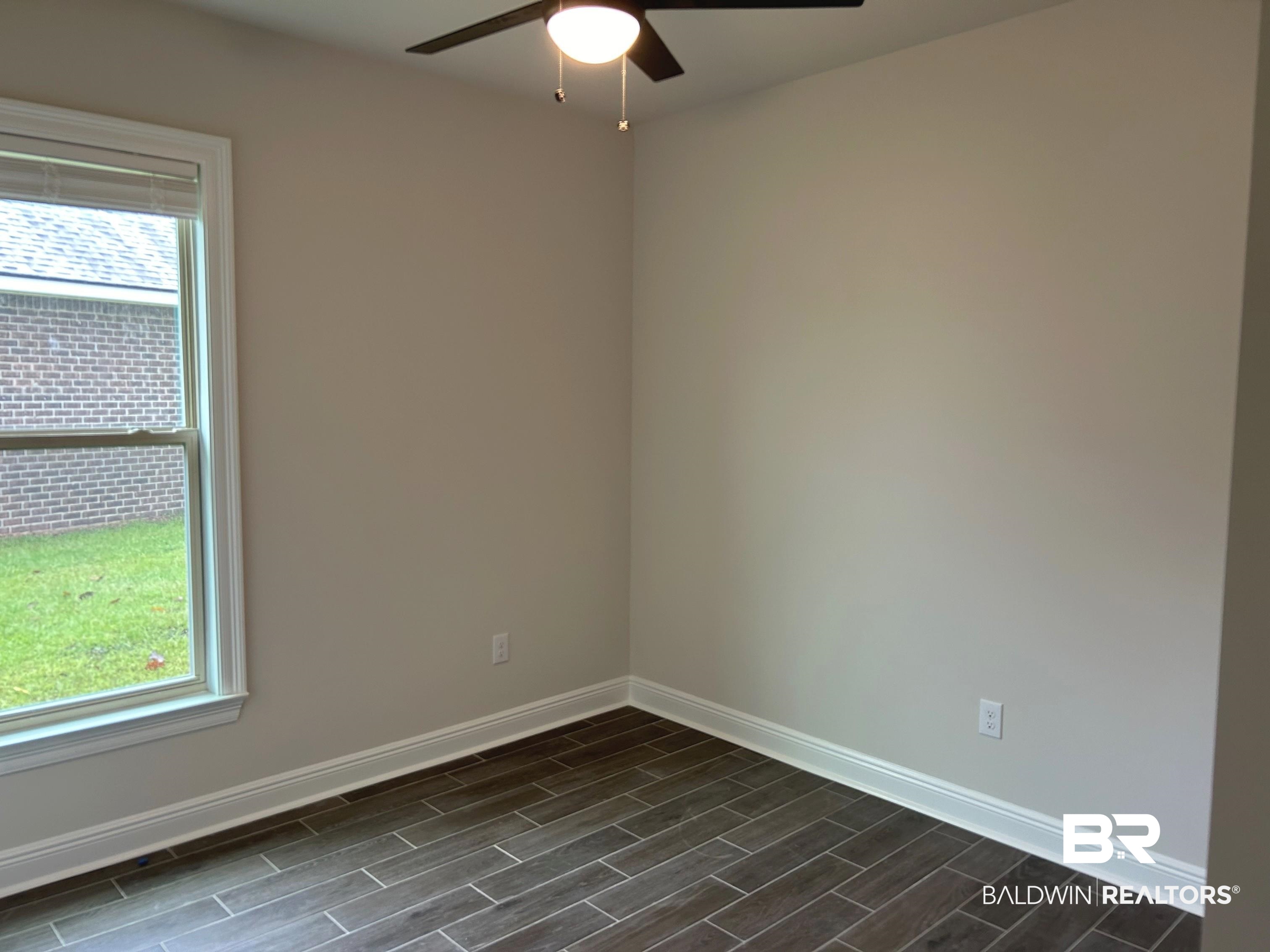 844 Sumter Loop Foley, AL 36535 - Photo 13 of 18 Empty room with dark wood-type flooring and ceiling fan