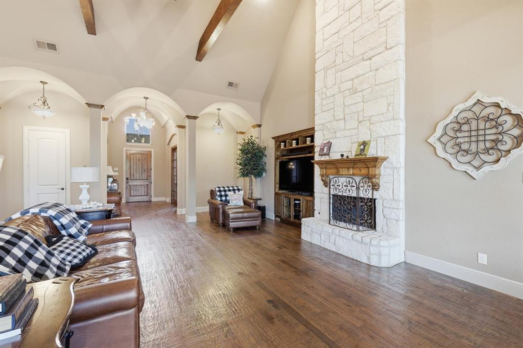 406 Spurgin Road Lucas, TX 75002 - Photo 7 of 39 Living area featuring arched walkways, a stone fireplace, hardwood / wood-style floors, and vaulted ceiling