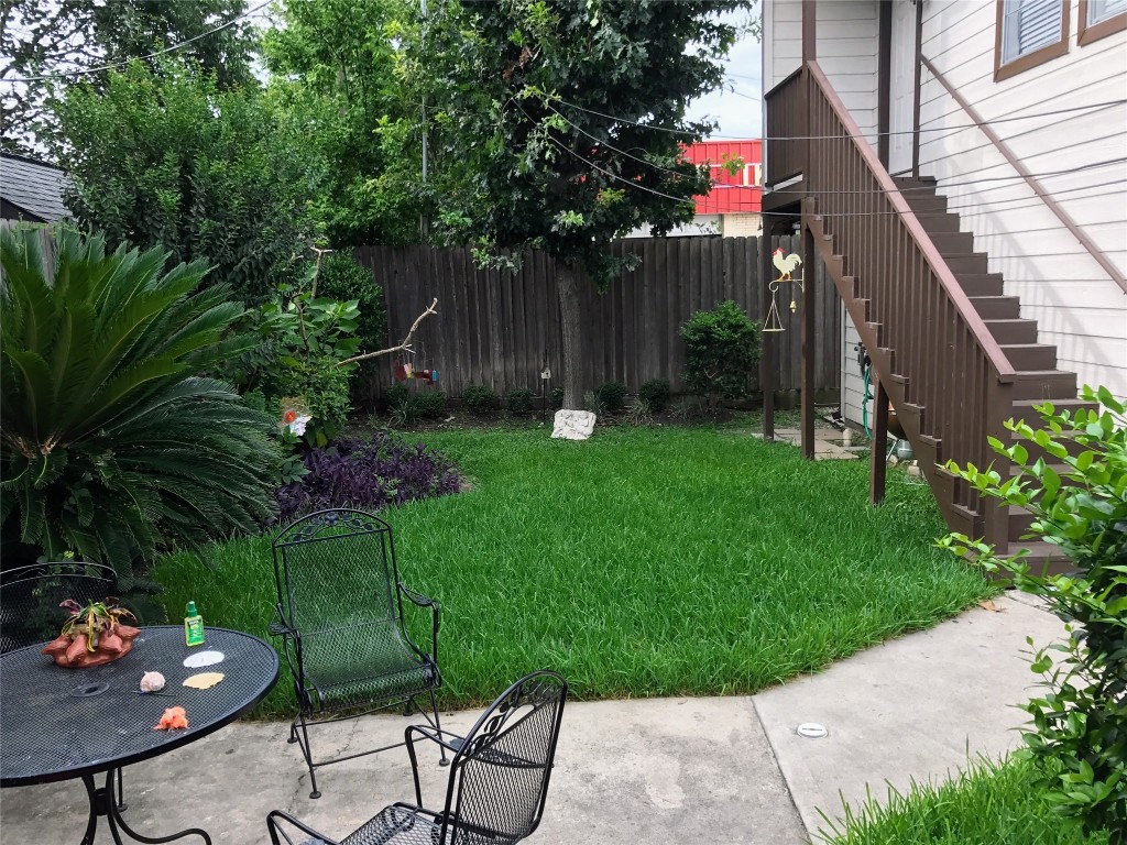 2106 Colquitt Street Houston, TX 77098 - Photo 29 of 31 a backyard of a house with table and chairs plants and large tree