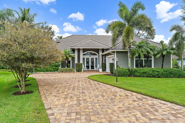 a front view of a house with a yard and potted plants