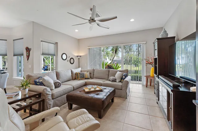 a living room with furniture a floor to ceiling window and a flat screen tv