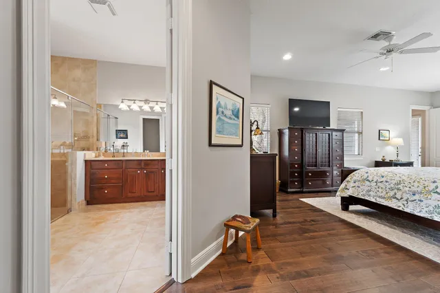 a bedroom with a bed a chair and a chandelier