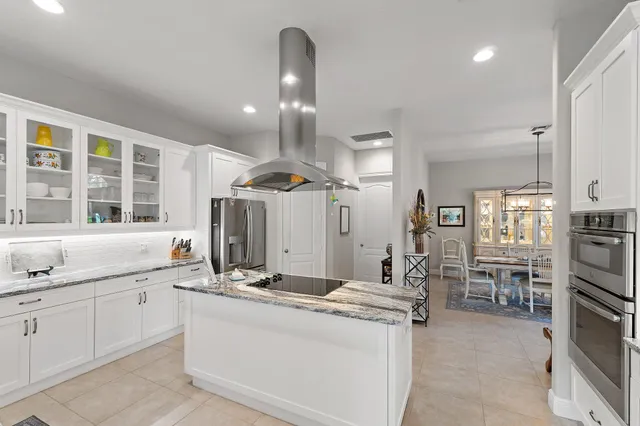 a large kitchen with kitchen island a large counter space a sink stainless steel appliances and cabinets
