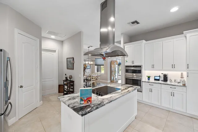 a kitchen with granite countertop a sink stainless steel appliances and cabinets