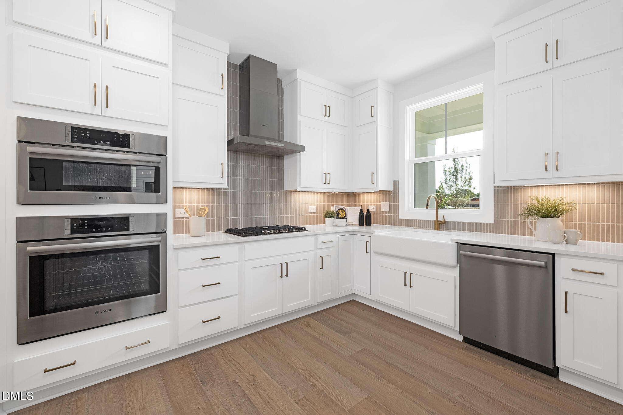 2412 Adrift Road Fuquay-Varina, NC 27526 - Photo 4 of 19 a kitchen with stainless steel appliances white cabinets and a stove a oven with wooden floors