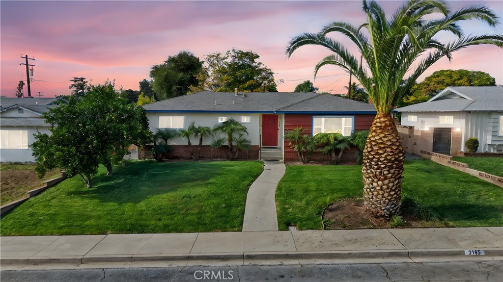 a front view of a house with a garden and plants