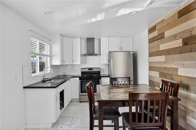 a kitchen with a dining table chairs and refrigerator