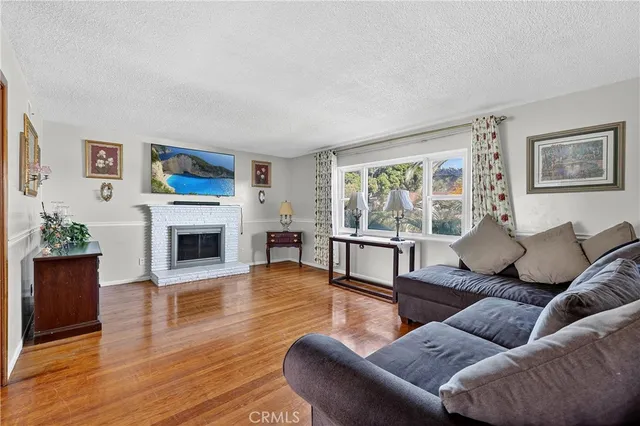 a living room with furniture a fireplace and a floor to ceiling window