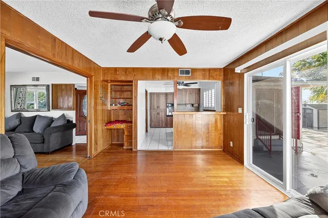 a living room with furniture and a large window with kitchen view