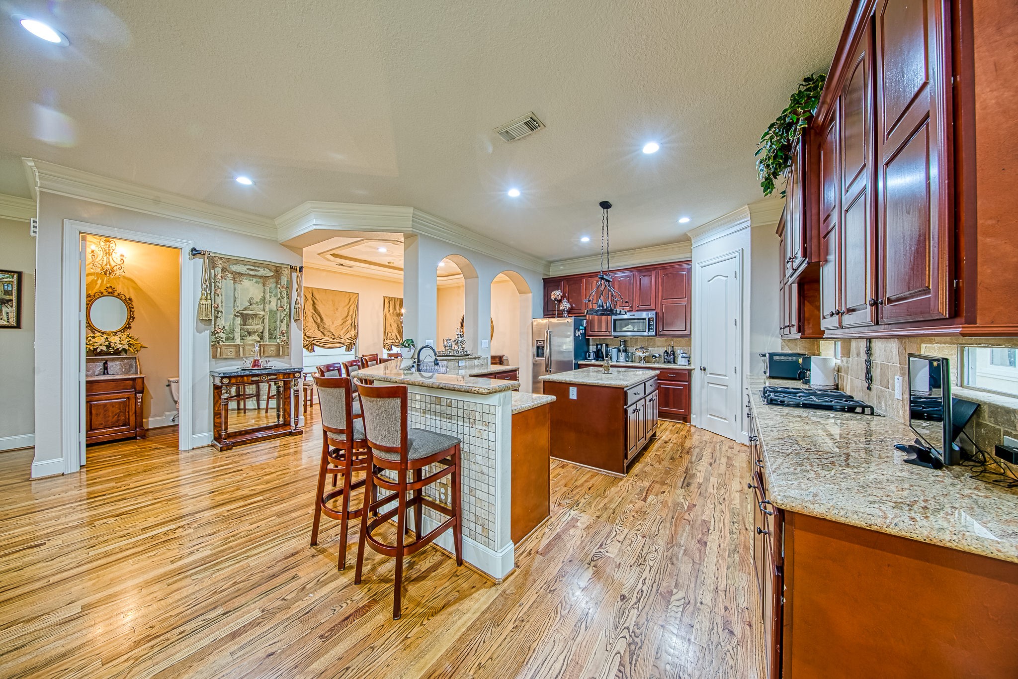 6310 Hamman Street, Unit D Houston, TX 77007 - Photo 15 of 41 a kitchen with stainless steel appliances granite countertop wooden floor a stove top oven a dining table and chairs
