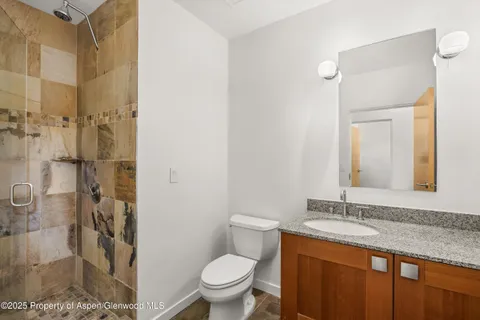 a bathroom with a granite countertop sink toilet and shower