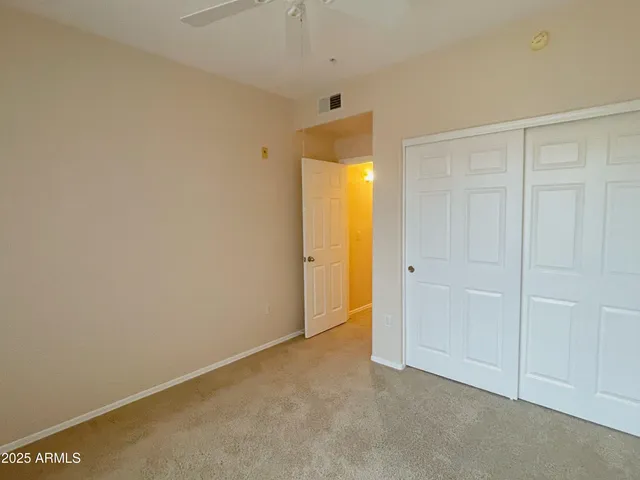 an empty room with a window and a fan