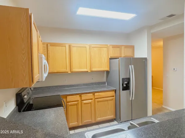 a kitchen with stainless steel appliances granite countertop a refrigerator and a stove