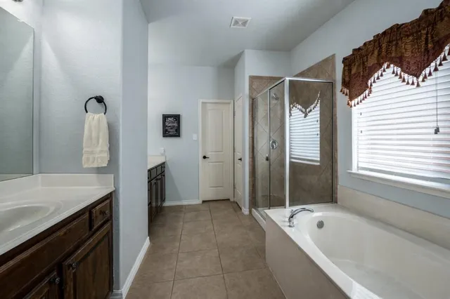 a bathroom with a tub sink and mirror
